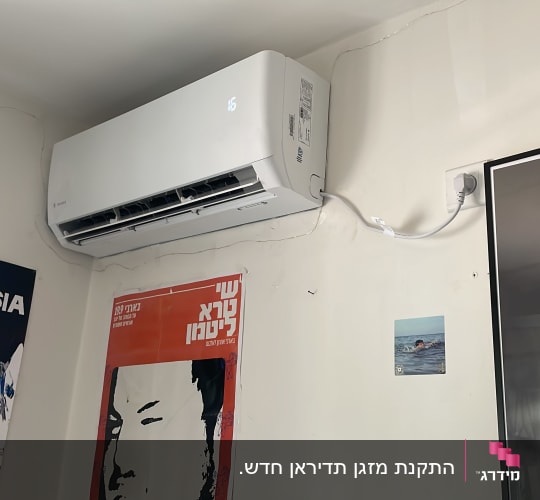 מזגן מותקן על קיר עם כבל חשמל מחובר